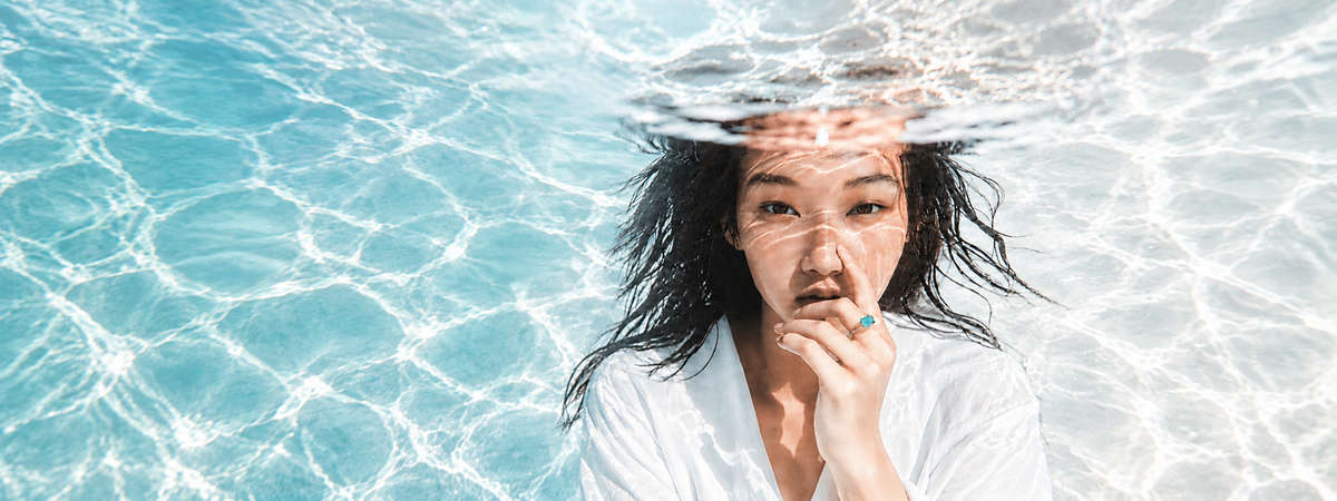 Femme aux cheveux mouillés sous la surface de l'eau, évoquant la détente du head spa
